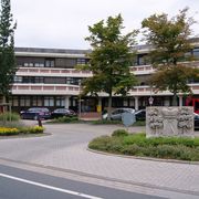 Das Rathaus der Stadt Aurich vom Fischteichweg aus gesehen. Im Vordergrund der Wappenstein. 